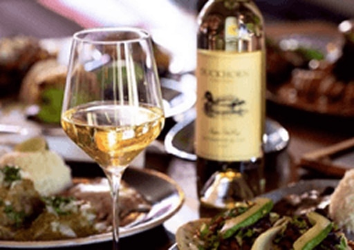Glass of white wine and dinner setting at an El Segundo restaurant for a relaxed evening out.