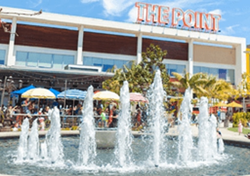 Fountain at The Point shopping center surrounded by outdoor restaurants and palm trees in El Segundo.