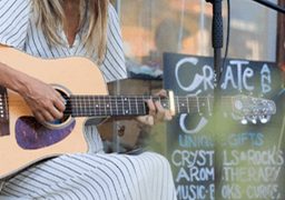 Musician playing guitar outside a local shop in El Segundo, representing arts and local culture.