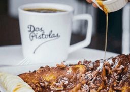 Cup of coffee and syrup being poured over French toast at Dos Pistolas café in El Segundo.