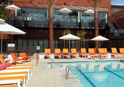 Modern hotel pool deck with lounge chairs and umbrellas in El Segundo.